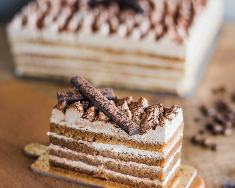 Layered tiramisu crepe cake dusted with cocoa